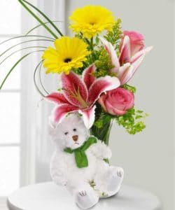 bright pink and yellow floral arrangement with sweet bear