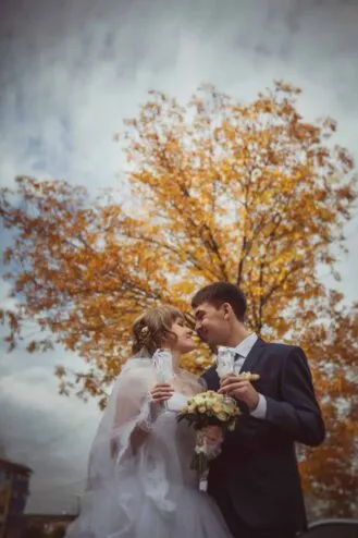 young bride and groom on the background of autumn landscape