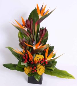 red berries birds of paradise and tropical greenery arrangement