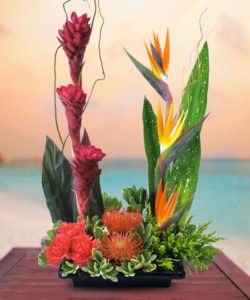Brilliant colorful birds of paradise, red torched ginger and other flowers are dramatically designed in this tropical arrangement to make a strong statement