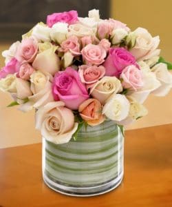 assorted pink white and blush roses in small round jar