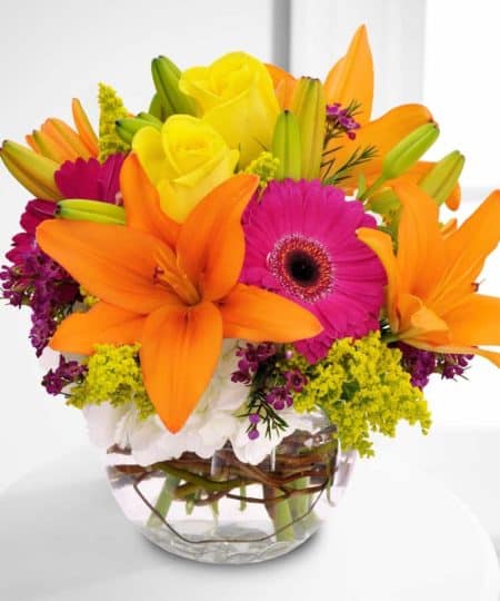 This bubble vase filled with orange lilies, hot pink gerbera daisies and yellow roses is bursting with warm wishes.