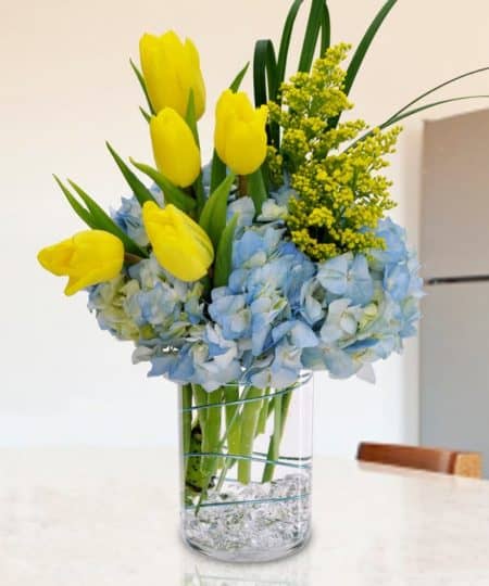 This stunning bouquet features blue hydrangea and yellow tulips artfully designed in a cylindrical glass vase, accented with gems at the bottom of the vase. A seasonal best seller, Springtime Bouquet is sure to put a smile on any lucky recipient's face! 