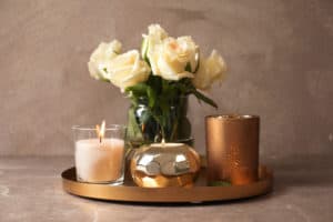 Copper tray with white roses and three copper and gold candles